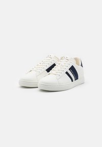 Sneakers bianchi in pelle con strisce blu navy, punta rotonda, suola piatta in gomma e dettagli in tessuto sul tallone. Design con lacci e particolare con logo.