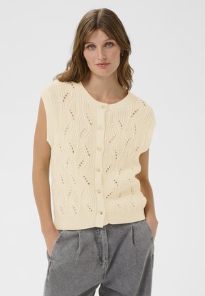 Knitted cream cardigan with a wave pattern, short sleeves, and button closure. Features a textured fabric and ribbed hem detail.