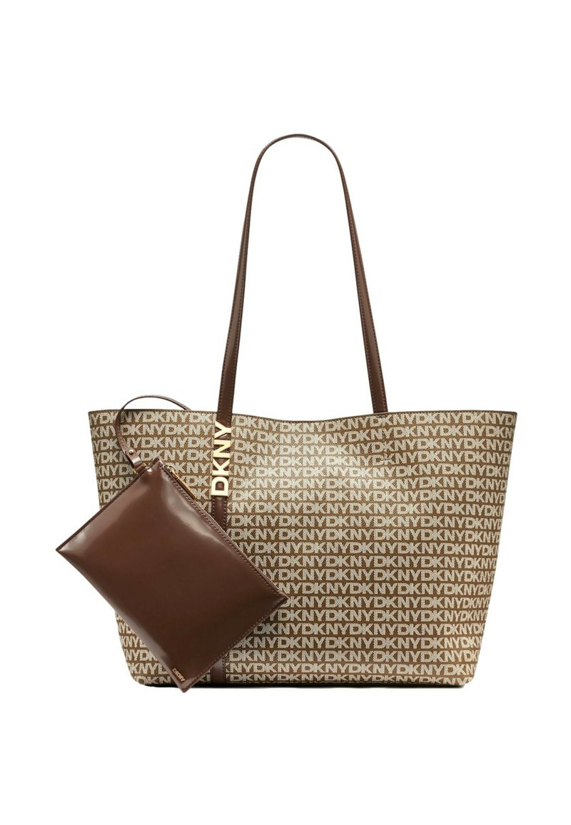 Hnedá taška na rameno s bielym potlačou loga DKNY, vybavená dvoma pevnými rukoväťami a priloženou hnedou kapsičkou na zips.