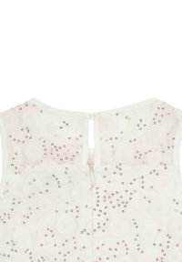 Weiße Bluse mit einem floralen Muster in hellem Pink und Pailletten. Reißverschluss hinten mit einem kleinen Schlüssellochöffnungs, runder Ausschnitt.