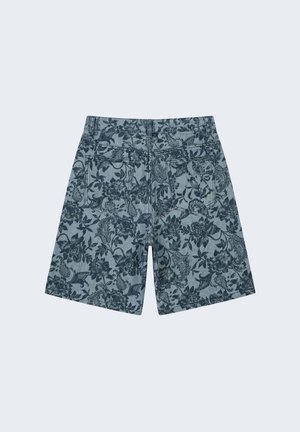 Pantalones cortos vaqueros con estampado floral oscuro, dos bolsillos traseros y trabillas para cinturón, mostrados por detrás sobre un fondo claro.