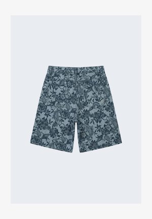 Pantalones cortos vaqueros con estampado floral oscuro, dos bolsillos traseros y trabillas para cinturón, mostrados por detrás sobre un fondo claro.