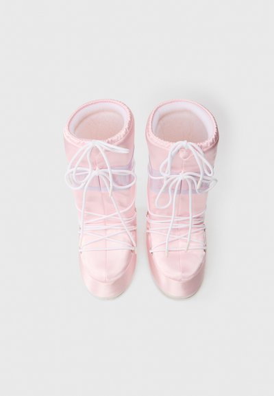 Botas de satén rosa con un interior acolchado, con cordones blancos y una abertura circular en la parte superior, diseñadas para la comodidad y el estilo.