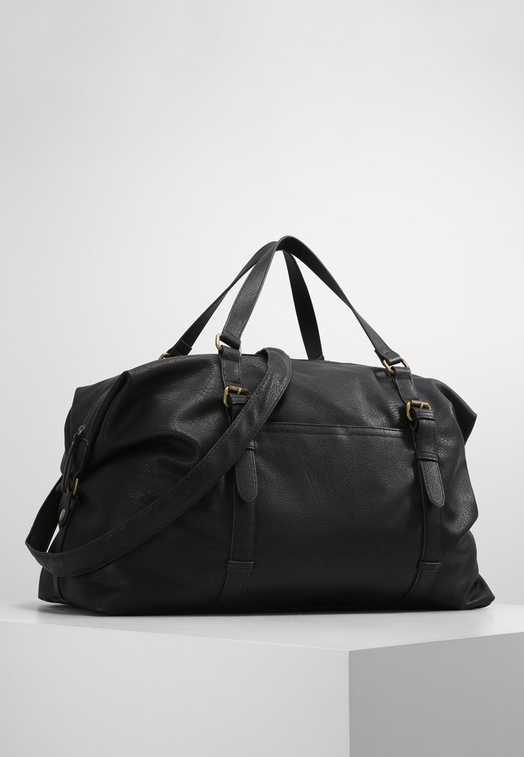 Borsa da viaggio in pelle nera con due manici superiori e una tracolla staccabile. Caratterizzata da accessori in tonalità oro, superficie testurizzata e chiusura con zip.