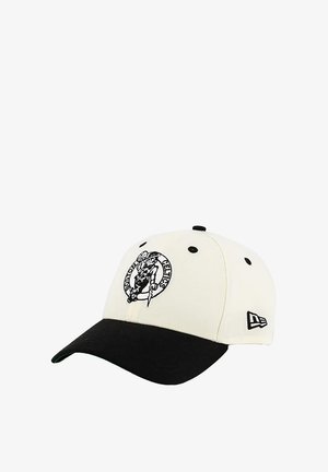 White baseball cap with a black brim. Features an embroidered logo of a leprechaun and "Celtics" in black. Made of cotton material.