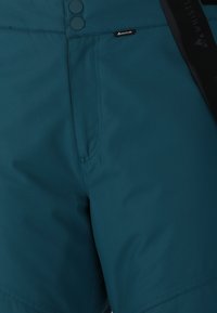 Teal vandringsshorts i lättviktsmaterial har dubbla knappar, en framficka och ett justerbart svart bälte med en logotyp.