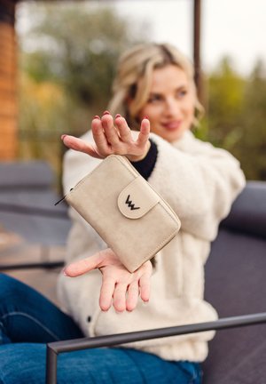 Beige wallet with a flap closure and a logo. Made of smooth material, rectangular shape, featuring a zipper and visible stitching details.