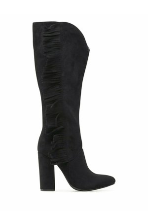 Czarny zamszowy kozak za kolano z klockowym obcasem i detalem z frędzlami biegnącymi pionowo wzdłuż zewnętrznej strony.