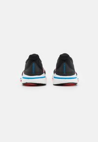 Zwarte hardloopschoenen met een bovenwerk van mesh, voorzien van blauwe en roze accenten, een gevoerde witte tussenzool en textuur rubberen loopzolen.