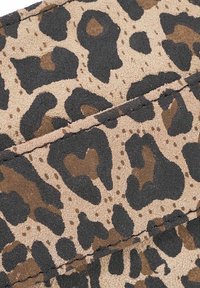 Tessuto a fantasia leopardo con texture morbida; i colori includono beige, nero e marrone in motivi irregolari. Cuciture visibili sui bordi.