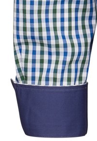 Camicia a quadri con motivi blu, verdi e bianchi; presenta un polsino blu scuro. Il tessuto appare liscio con una vestibilità strutturata.