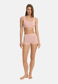 Ljust rosa sportbehå och shorts-set, mjukt tyg, slät textur, åtsittande design, breda axelband och elastisk midjebands för komfort.