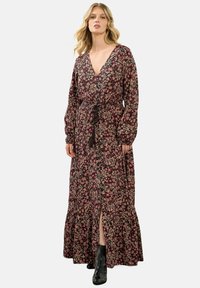 Czarna sukienka maxi w kwiaty w odcieniach różu i kremu, z długimi rękawami, głębokim dekoltem w kształcie litery V, wcięciem w talii i warstwową spódnicą z bocznym rozcięciem.