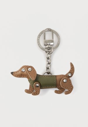 Porte-clés en forme de teckel marron avec un corps vert, agrémenté d'accents argentés et d'une boucle pour fixation. Fabriqué en matière semblable au cuir.