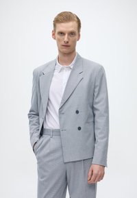 Ανοιχτό γκρι, διπλό ραμμένο σακάκι με διακριτό σχέδιο ρίγας, συνδυασμένο με λευκό πουκάμισο με γιακά. Κόψιμο που ταιριάζει, απαλό υφασμάτινο υλικό.