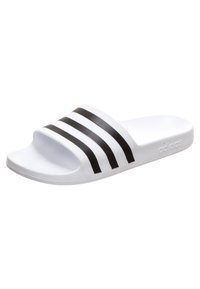 Bílé plážové sandály z umělého materiálu, s třemi černými paralelními pruhy přes horní část a texturovanou podrážkou pro lepší grip.