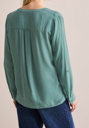 Green striped long-sleeve shirt with a round neckline and buttoned cuffs; relaxed fit and gathered detailing at the back.