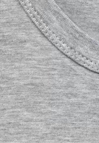 Tela de algodón gris con una textura suave, que muestra un escote redondo y costuras visibles a lo largo del borde, creando un acabado limpio.