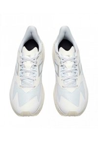 Scarpe da ginnastica bianche con tomaia in rete con motivi a zigzag, dettagli grigio chiaro, interno nero e lacci piatti. Design della suola arrotondato.