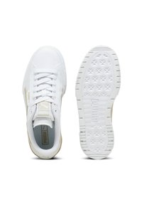 Zapatillas deportivas blancas con una parte superior sintética suave, detalles en beige, cordones planos y una suela de goma texturizada con patrones de estrellas.