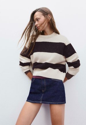 Maglione a righe in misto lana crema e marrone scuro, con maniche lunghe e collo girocollo. Abbinato a una mini gonna in denim scuro.