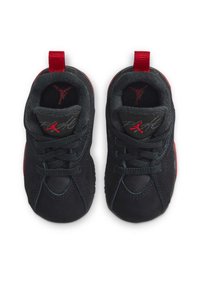 Chaussures de sport noires avec des accents rouges, présentant un dessus lisse, un système de laçage et un logo sur la semelle intérieure. Bout arrondi et col rembourré.