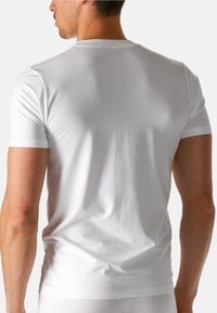 Hvid kortærmet t-shirt lavet af bomuld. Fittet design med glat tekstur og rund hals, viser en ensfarvet bagside uden grafik.