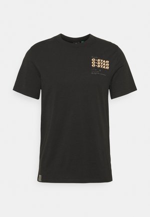T-shirt en coton noir à manches courtes, avec le texte imprimé orange "G-STAR" en haut à gauche sur le devant. Col rond classique.