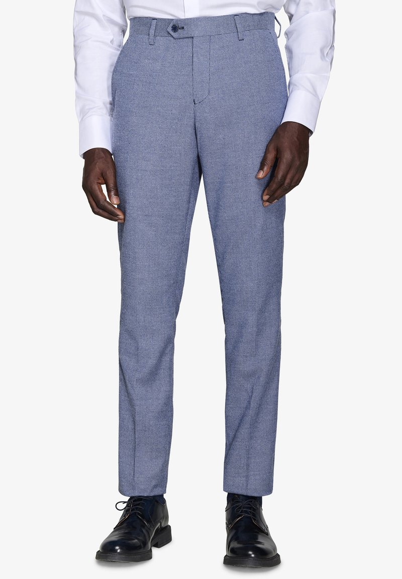 Jasnoniebieskie spodni w wzory o slim fit, z gładkim przodem, szlufkami na pasek i płaskim pasem, zestawione z wypastowanymi czarnymi butami.