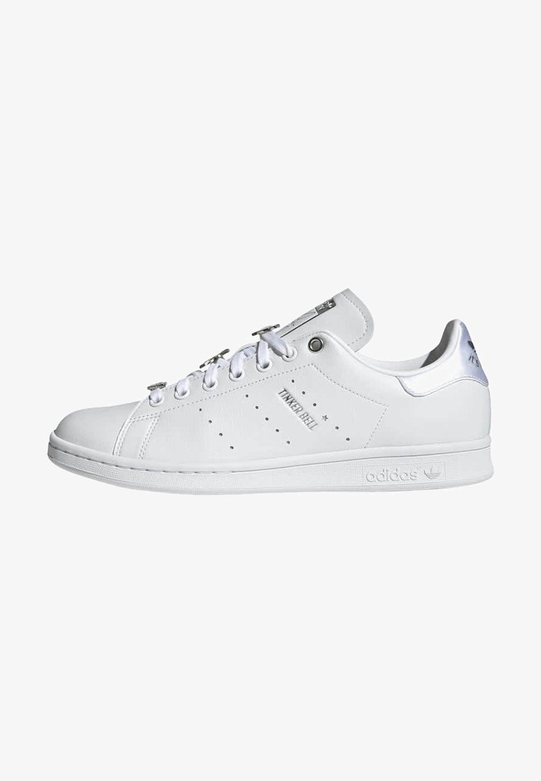 White leather sneakers with circular perforations, silver accents, and white rubber sole. Features flat laces and a classic low-top design.