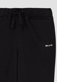 Zwarte trainingsbroek met elastische tailleband en drawstring, voorzien van een klein wit "SLVR" logo op de linker dij. Zachte textuur, casual ontwerp.