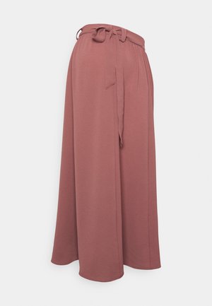 Pantalon taille haute à jambes larges couleur rose poudré avec une ceinture en tissu nouée à la taille, confectionné dans une matière texturée.
