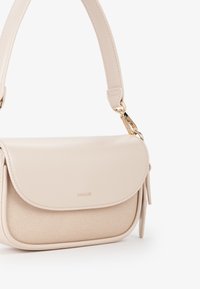 Borsa a tracolla beige con tasca frontale in tessuto testurizzato, chiusura a patta liscia, tracolla corta e dettagli in metallo dorato.