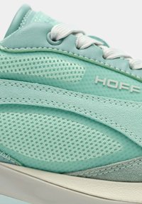 Zapatillas verde menta que combinan cuero liso y malla transpirable, con texturas contrastantes y cordones blancos para un ajuste seguro.