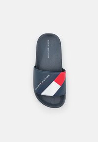 Granatowe klapki z teksturowaną podeszwą. Posiadają szeroki pasek w kolorze czerwonym, białym i niebieskim oraz znakowanie "TOMMY HILFIGER".