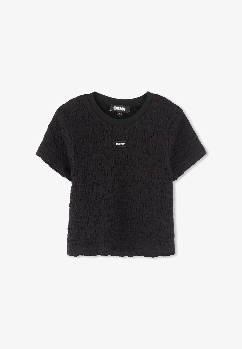 T-shirt noire court en tissu texturé, col rond et manches courtes. Présente un petit logo DKNY au centre.