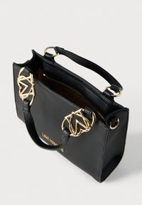 Μαύρη δερμάτινη τσάντα χειρός με υφή, χρυσά μεταλλικά στοιχεία και κεντρικό φερμουάρ. Διαθέτει κοντές λαβές και λογότυπο «LOVE MOSCHINO».