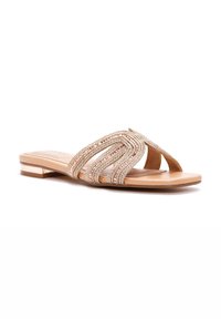 Sandalia plana con suela beige y tiras trenzadas metálicas en tonos dorados y rosas, con un pequeño tacón cuadrado y diseño de punta abierta.