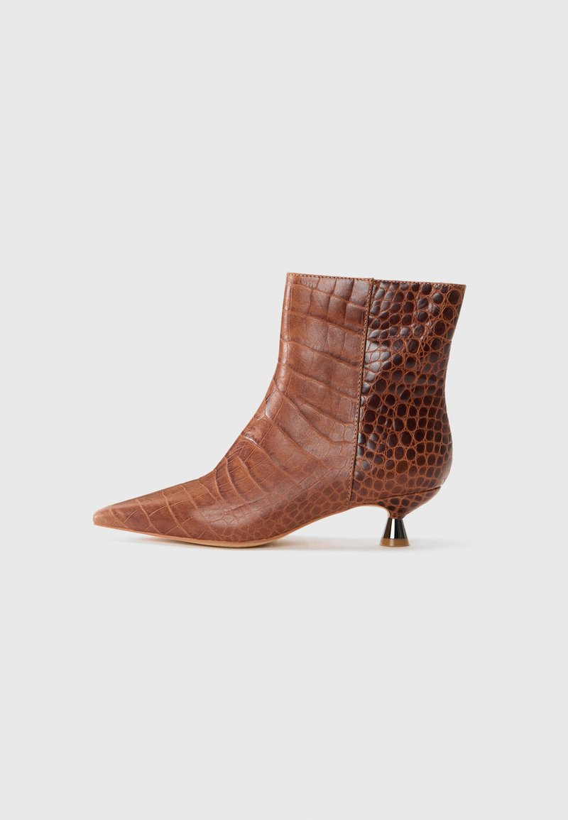 Braune Leder-Ankle-Boots mit spitzer Zehenform, die eine Kombination aus glatten und krokodilgeprägten Texturen aufweisen, und einem niedrigen, metallischen Absatz.