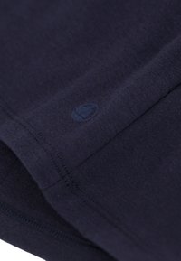 Navyblauwe katoenen t-shirt met een klein logo nabij de zoom, met een gladde textuur en een eenvoudig, klassiek ontwerp.