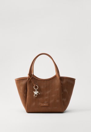 Sac tote tissé marron avec des poignées en cuir, mettant en avant un accessoire en porte-clés et un design structuré, ouvert sur le dessus. Matériau tissé texturé.