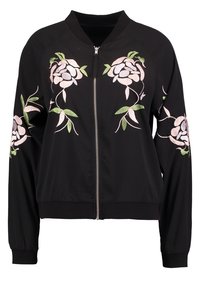 Svart bomberjacka med broderade rosa blommor och gröna blad på framsidan. Dragkedjestängning och ribbade muddarna fulländar designen.