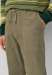 Khaki corduroy broek met een rechte pasvorm, voorzien van zijzakken en een elastische trekkoord tailleband. Zacht geribde textuur.