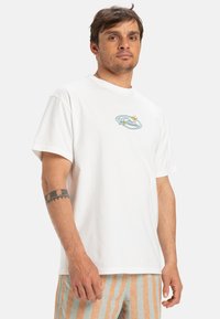 White cotton t-shirt featuring a graphic design of a wave and stars on the chest, round neckline, and short sleeves.