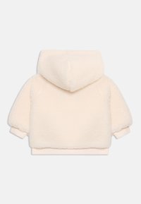 Felpa fluffy color crema con maniche lunghe, polsini a costine e cappuccio, vista da dietro su sfondo bianco.