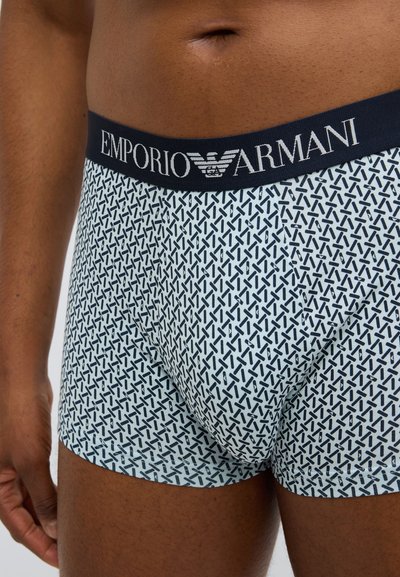 Μπλε και λευκά σλιπ μπόξερ με σχέδιο, με ναυτικό ελαστικό ζωνάρι στη μέση που φέρει το λογότυπο "Emporio Armani", παρουσιάζοντας γεωμετρικό μοτίβο.