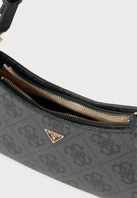 Czarna torba o fakturowanej powierzchni z zamknięciem na zamek błyskawiczny, ozdobiona złotym logo i gładką podszewką wewnętrzną. Elegancki design z subtelnymi wzorami.