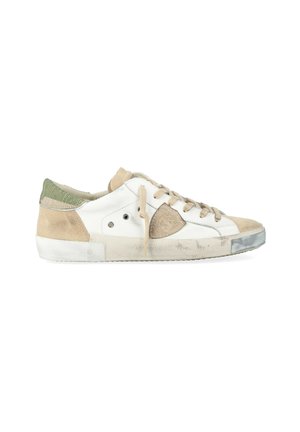 Sneaker bianco e beige con accenti in suede. Presenta lacci piatti, tallone testurizzato e suola in gomma. Segni di usura evidenti sulla punta e sul lato.
