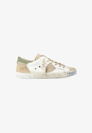 Baskets blanches et beiges avec des accents en suede. Présentent des lacets plats, un talon texturé et une semelle en caoutchouc. Usure notable sur les orteils et sur le côté.