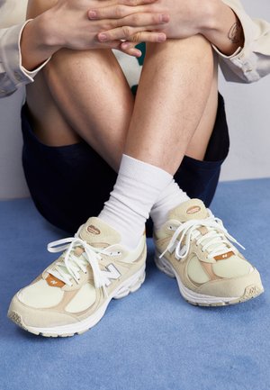 Lichtgroene New Balance sneakers met witte mesh en suede accenten, voorzien van witte veters, een ronde vorm en een comfortabele zool.